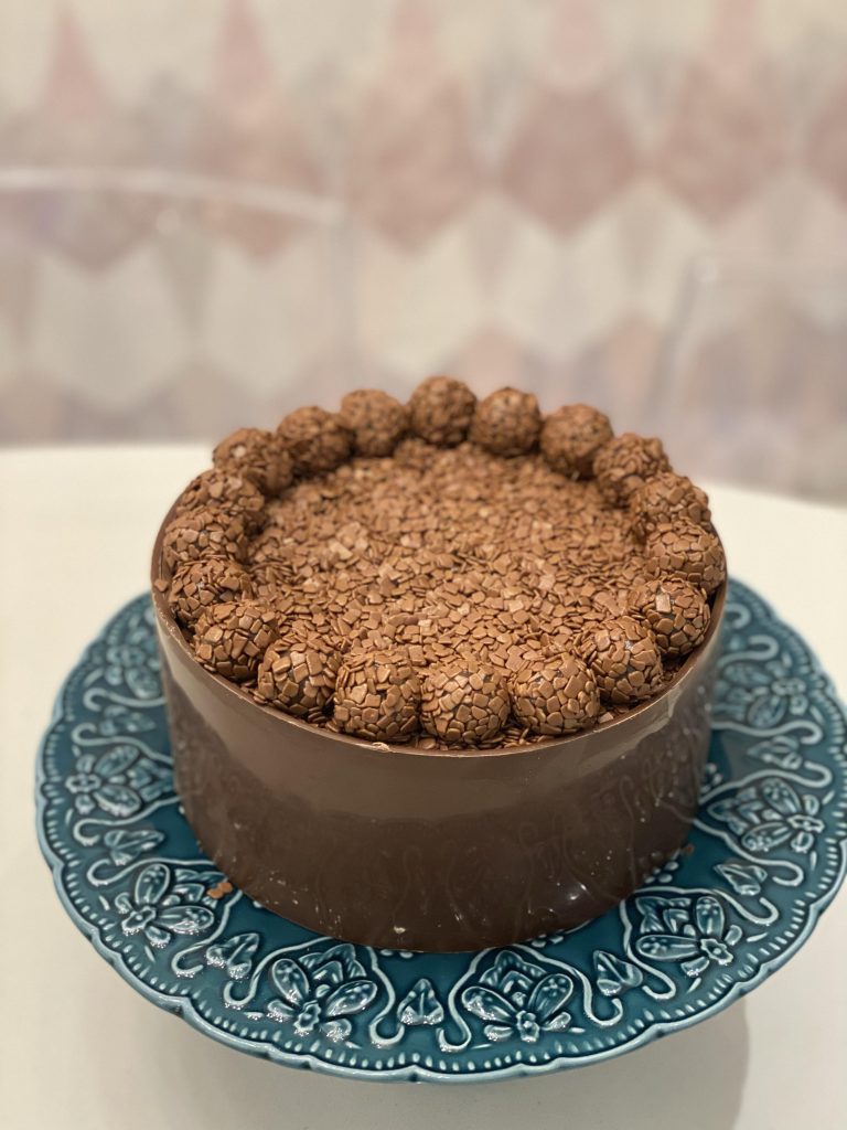 bolo de chocolate com brigadeiro e brigadeiros no topo